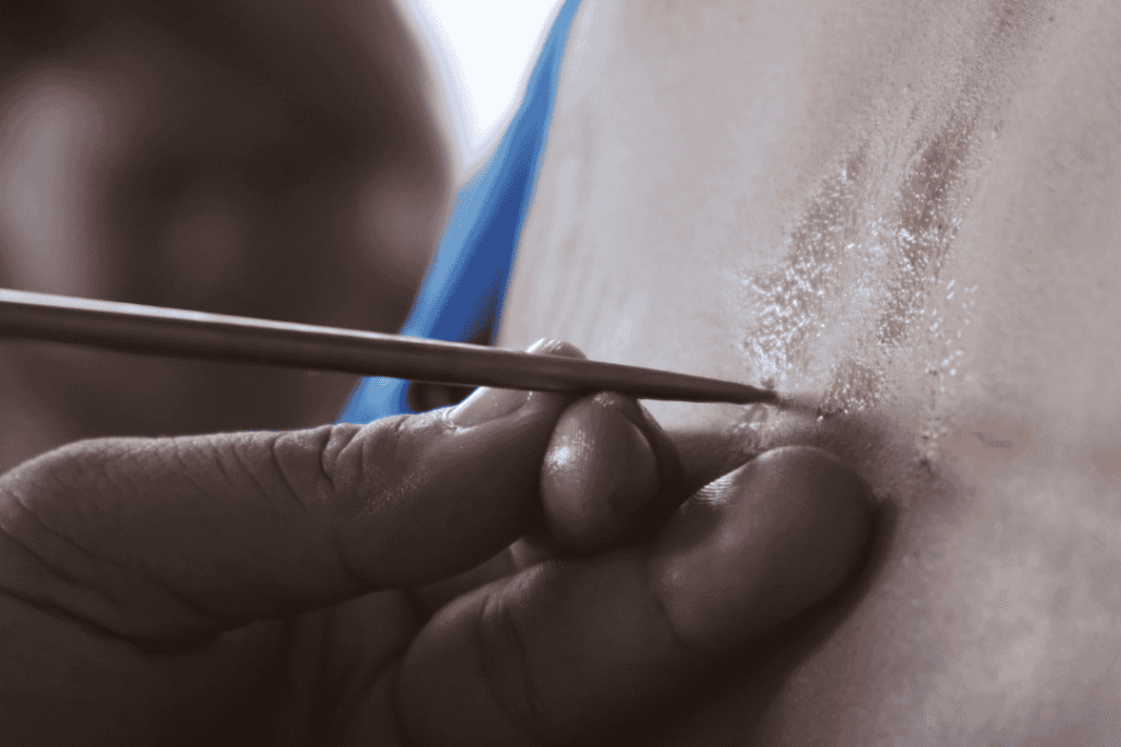 Proses ritual tato Sak Yant Thailand oleh biksu dengan batang logam tradisional