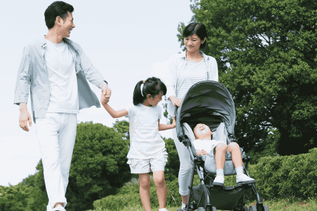 Keluarga dengan balita berjalan jalan sambil mendorong stroller balita