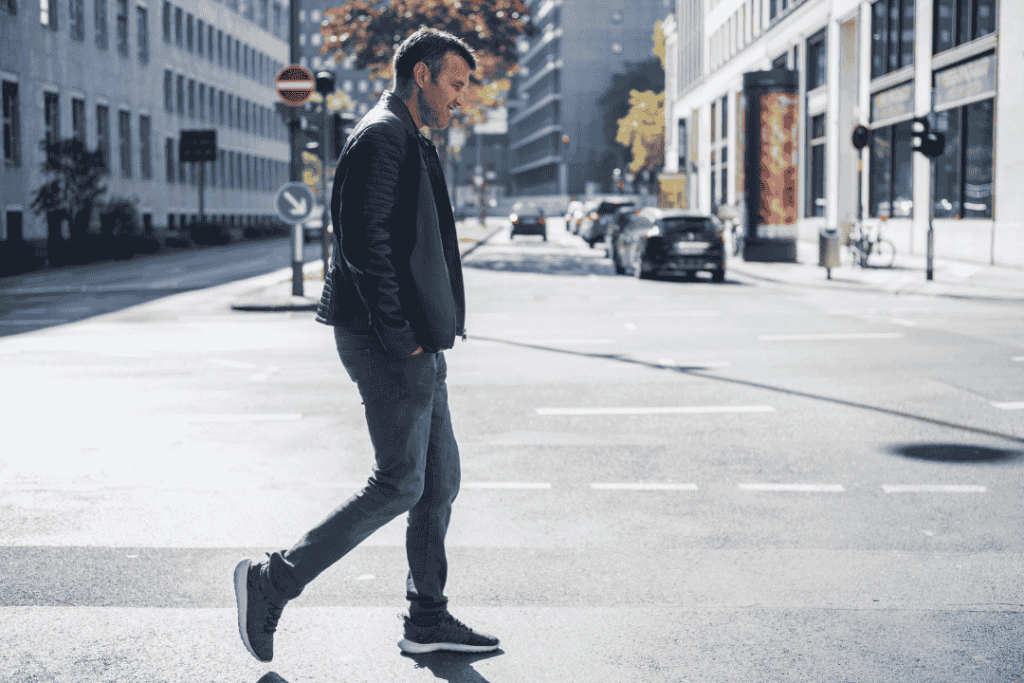 Seorang traveler berlari ringan di area perkotaan dengan sepatu sporty yang nyaman untuk aktivitas city walk.