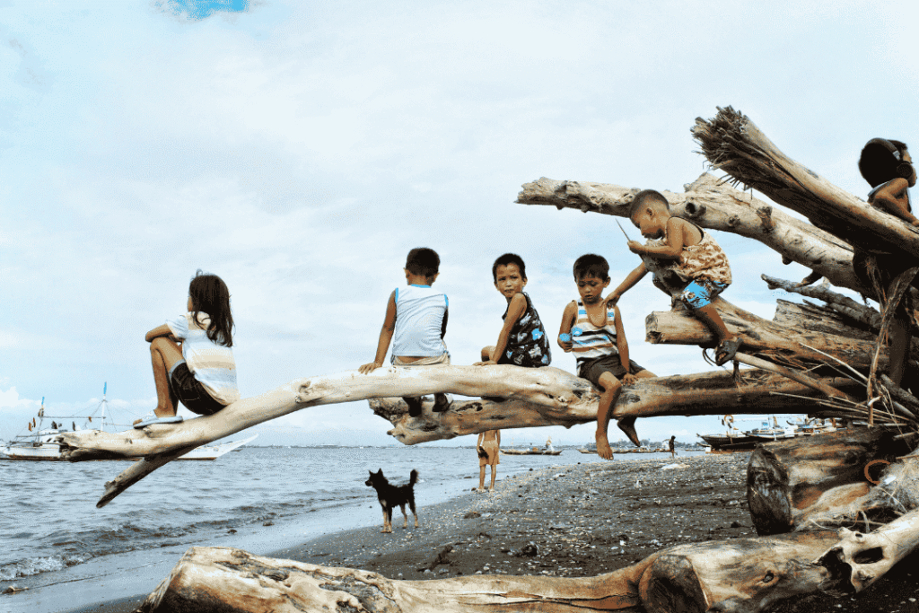 Seorang anak kecil bermain riang di pantai saat liburan keluarga