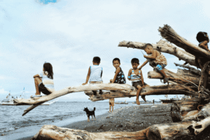 Seorang anak kecil bermain riang di pantai saat liburan keluarga