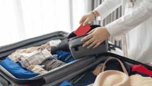 Traveler menata gadget seperti power bank, kamera, dan adaptor di atas meja sebelum berangkat