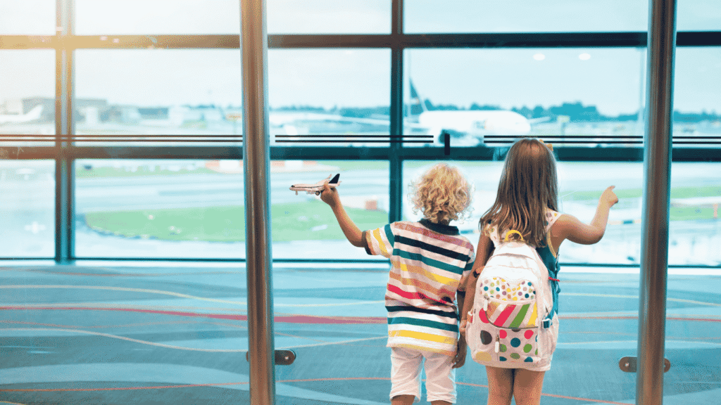 Dua orang anak sedang menatao pesawat sembari menunggu take off